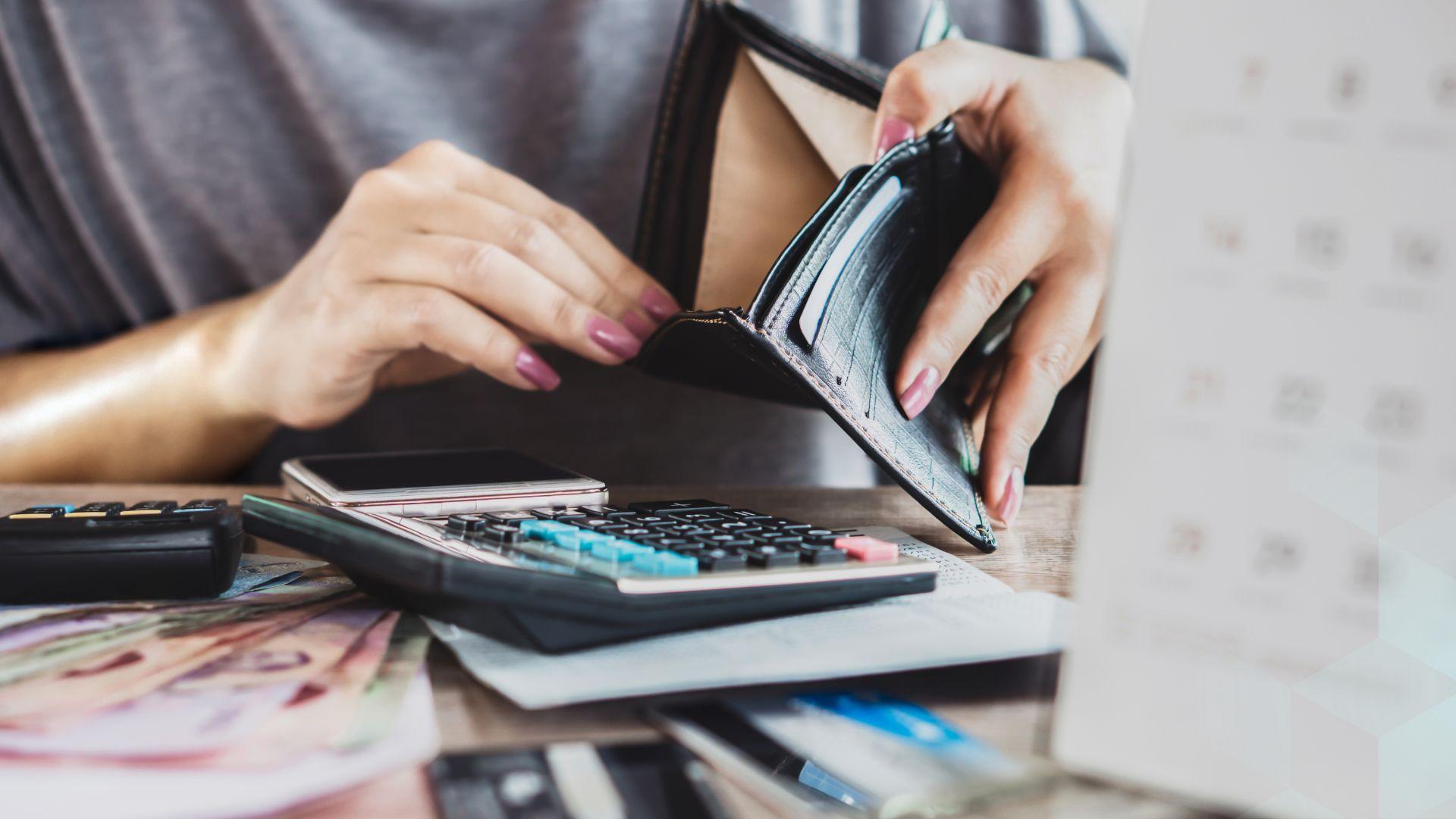 A woman holds open an empty wallet